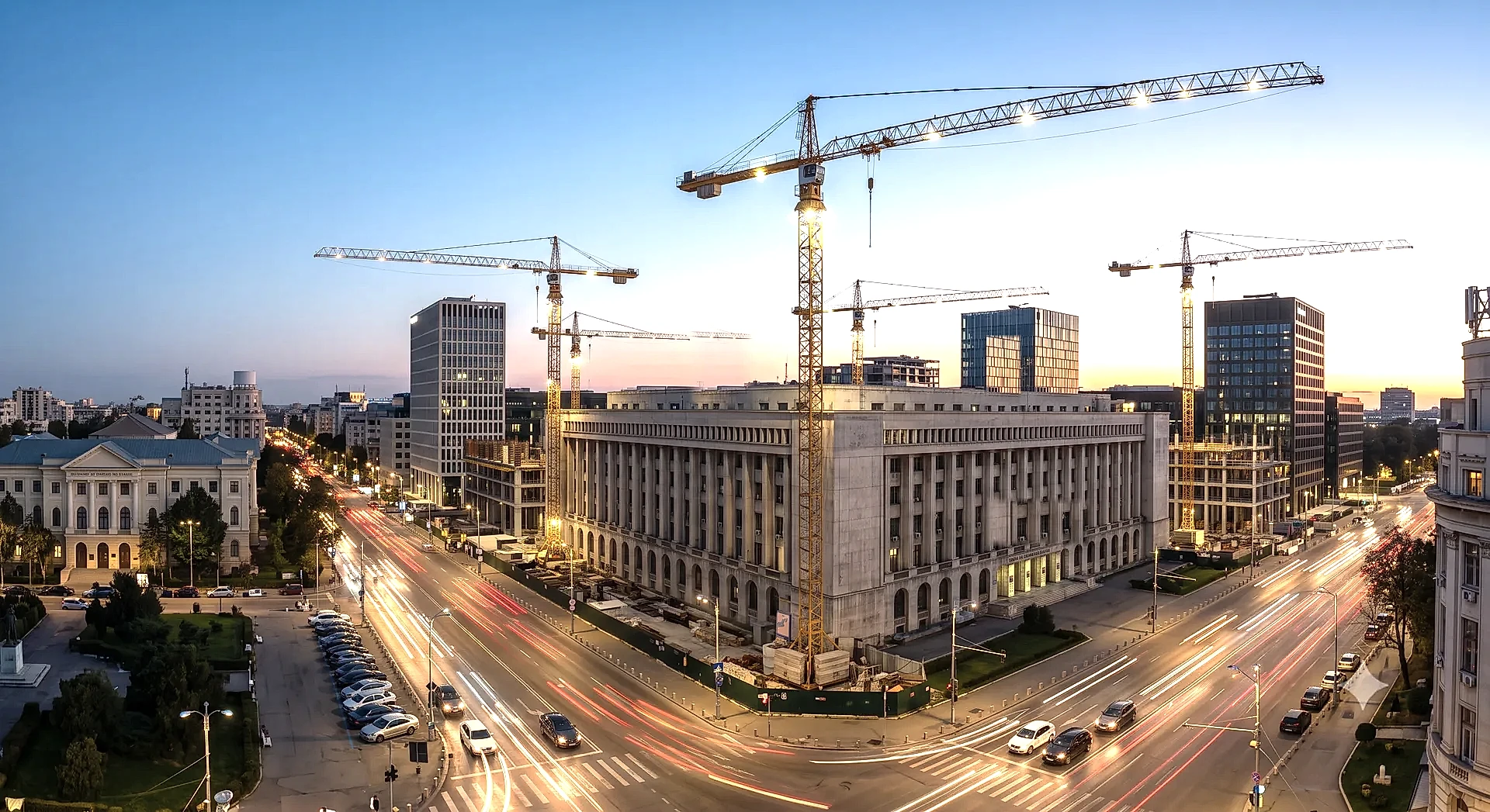 Bucuresti la ora albastra, cu macarale de constructie deasupra orasului si bulevard cu trafic